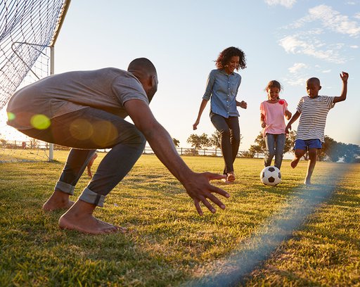/a-boy-kicks-a-football-during-a-game-with-his-family